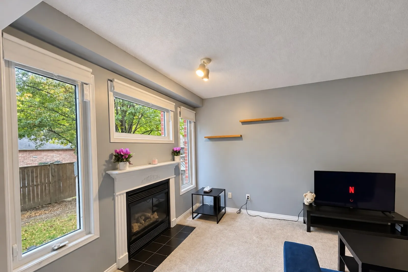 Gas fireplace and large windows looking onto the backyard