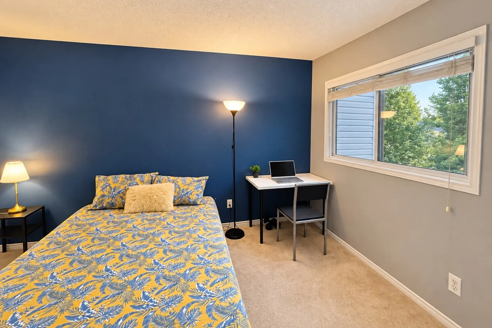 Desk with a chair and laptop by the window in the second bedroom