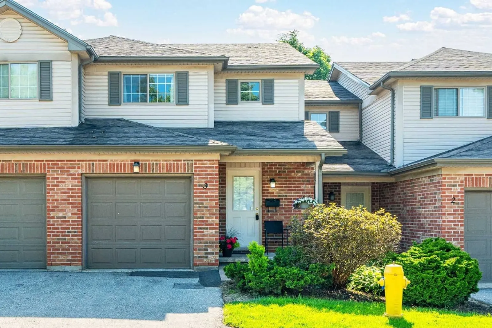 Brick-fronted townhouse with a garage and front garden